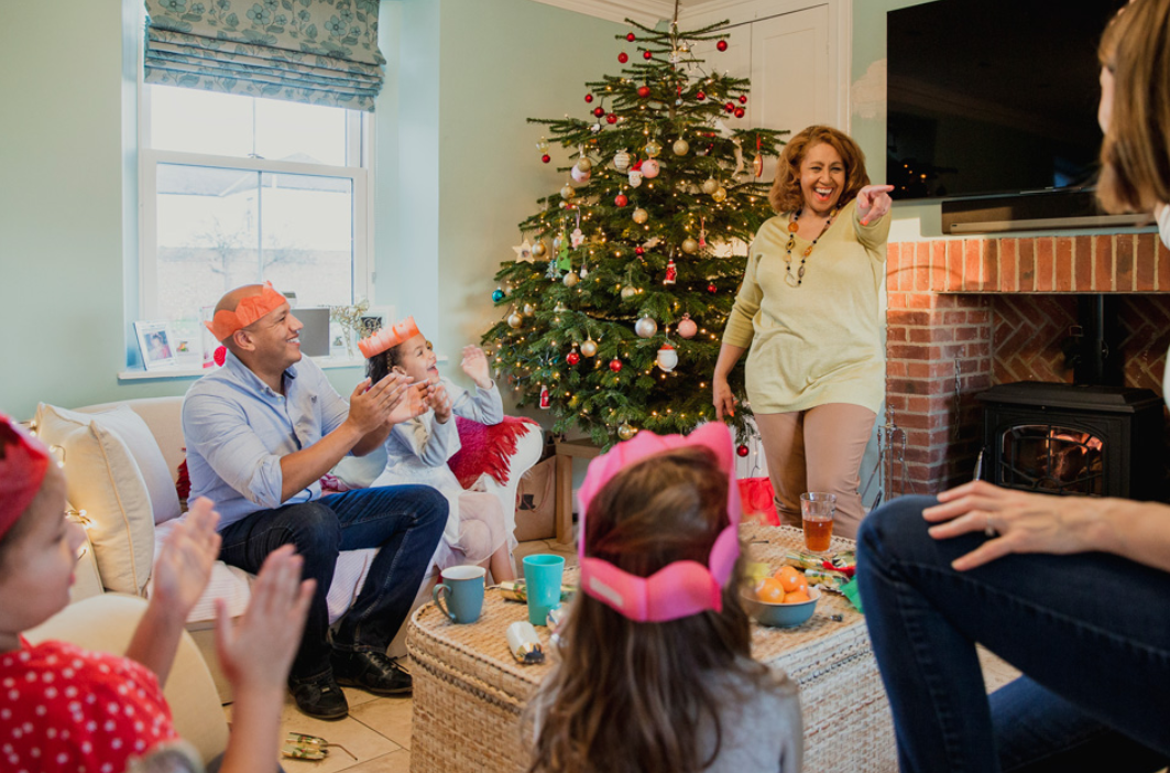 stock image of family playing games in their living room in front of a christmas tree 